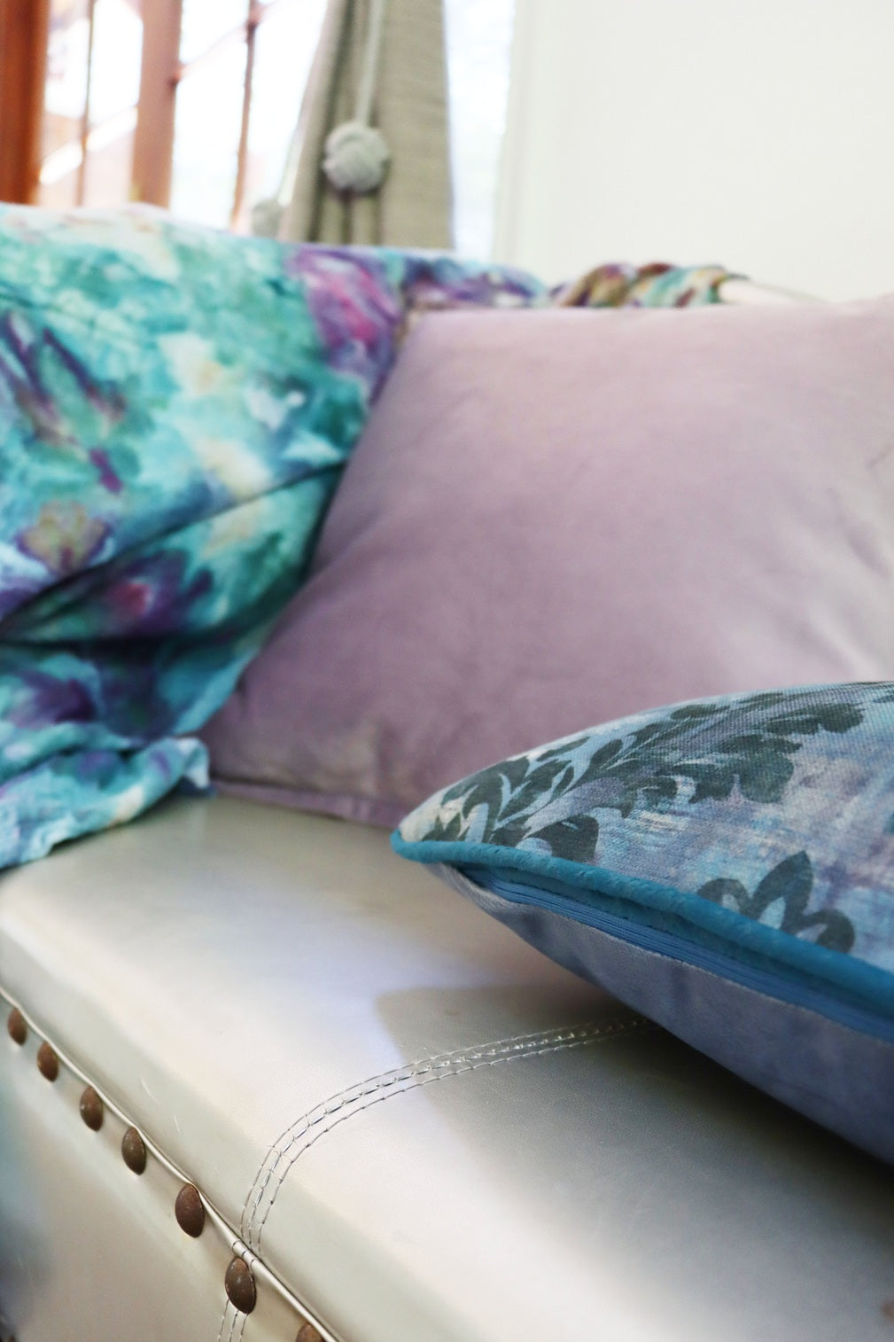 Close up of floral cushion cover with piped edge on a couch with a floral pattern
