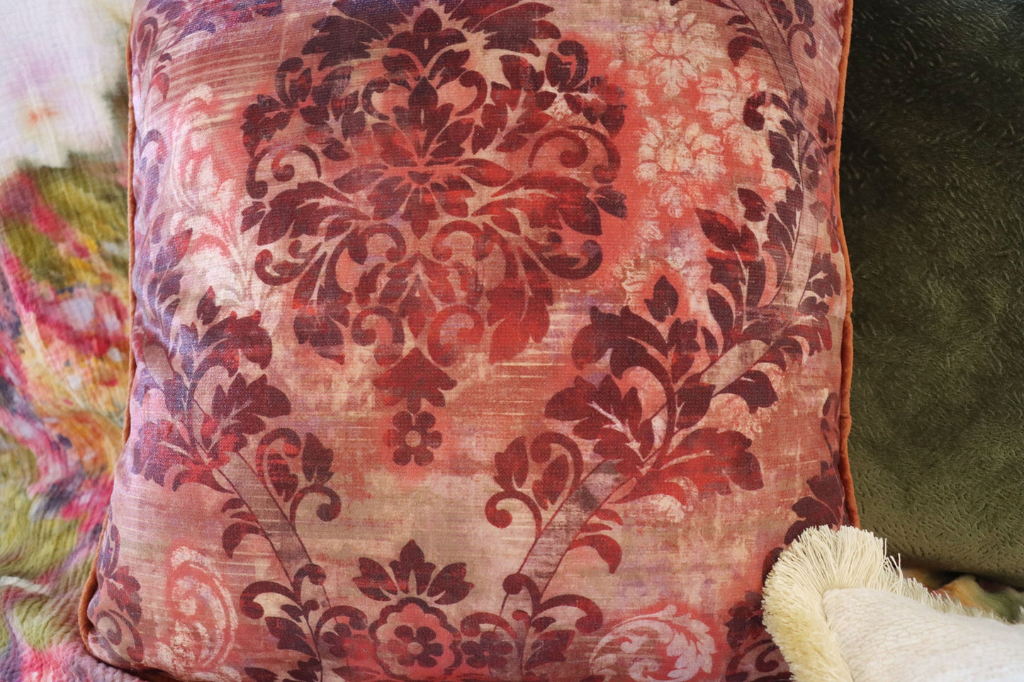 floral cushion cover with piped edge on a soft focus background
