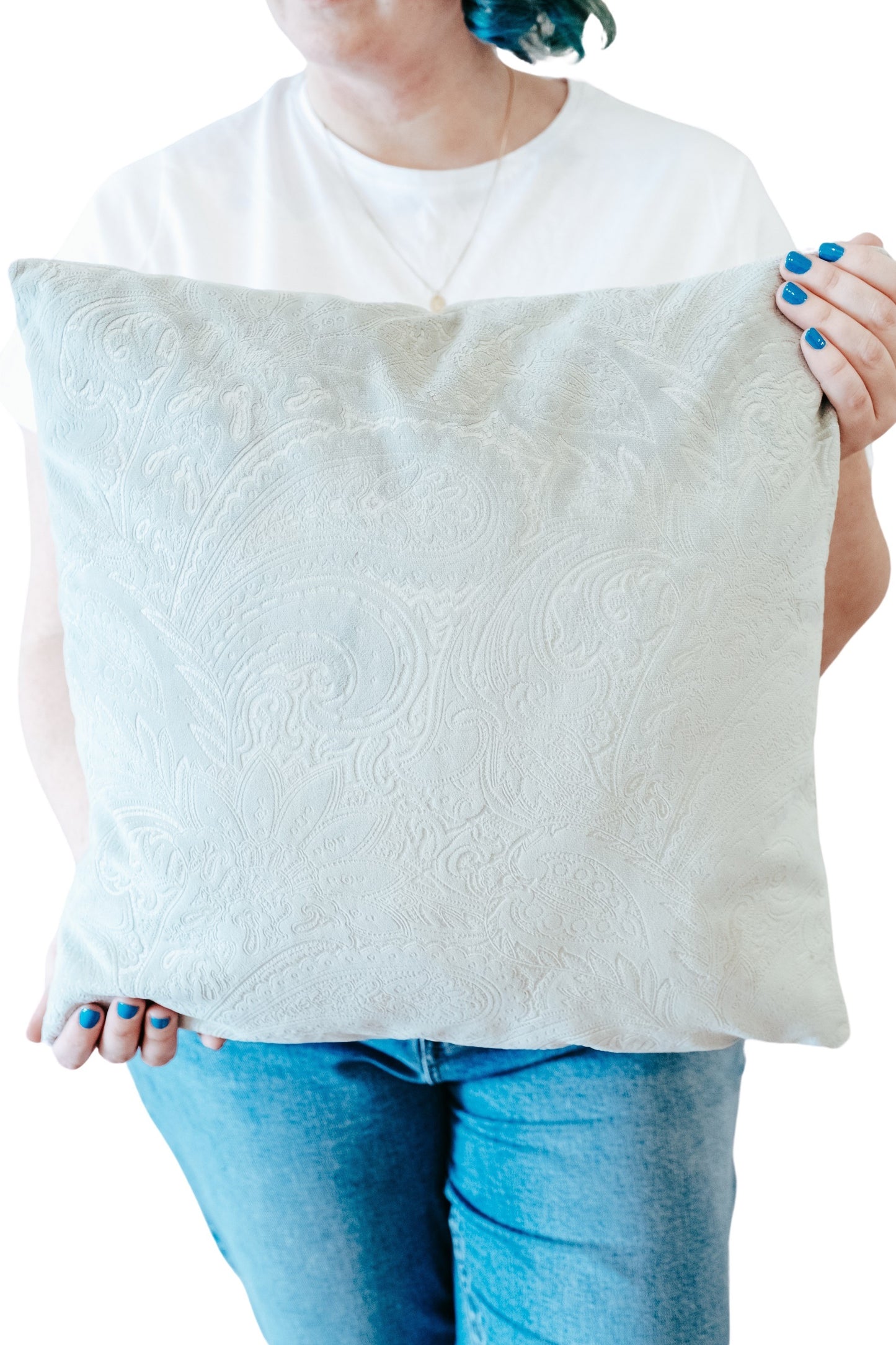 Person holding a pale green textured velvet cushion cover