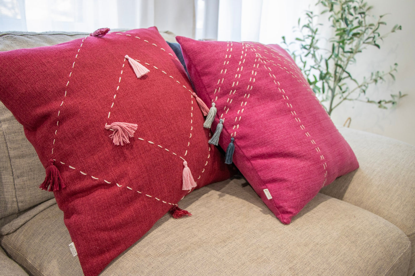 Pink handmade cushion cover with embroidery and tassels on Sofa