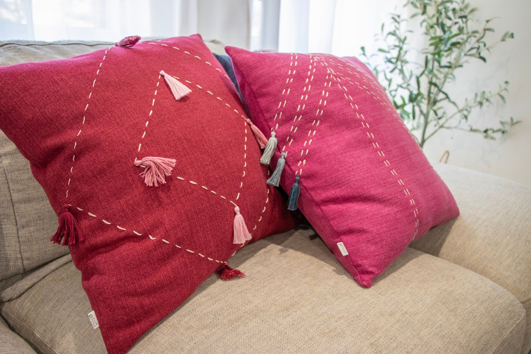 Pink handmade cushion cover with embroidery and tassels on Sofa