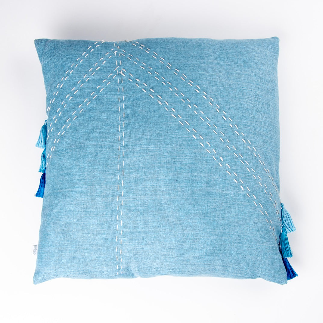 Front of blue geometric cushion cover with embroidery and tassels