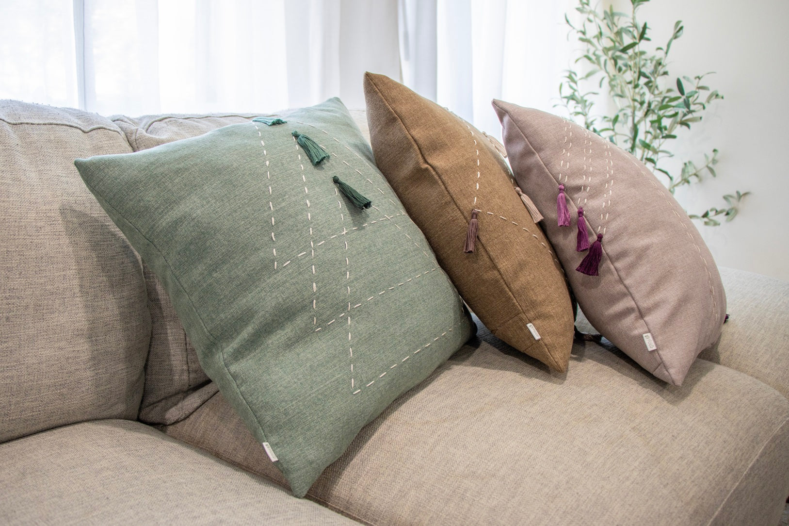 Handmade cushion cover with embroidery and tassels on sofa