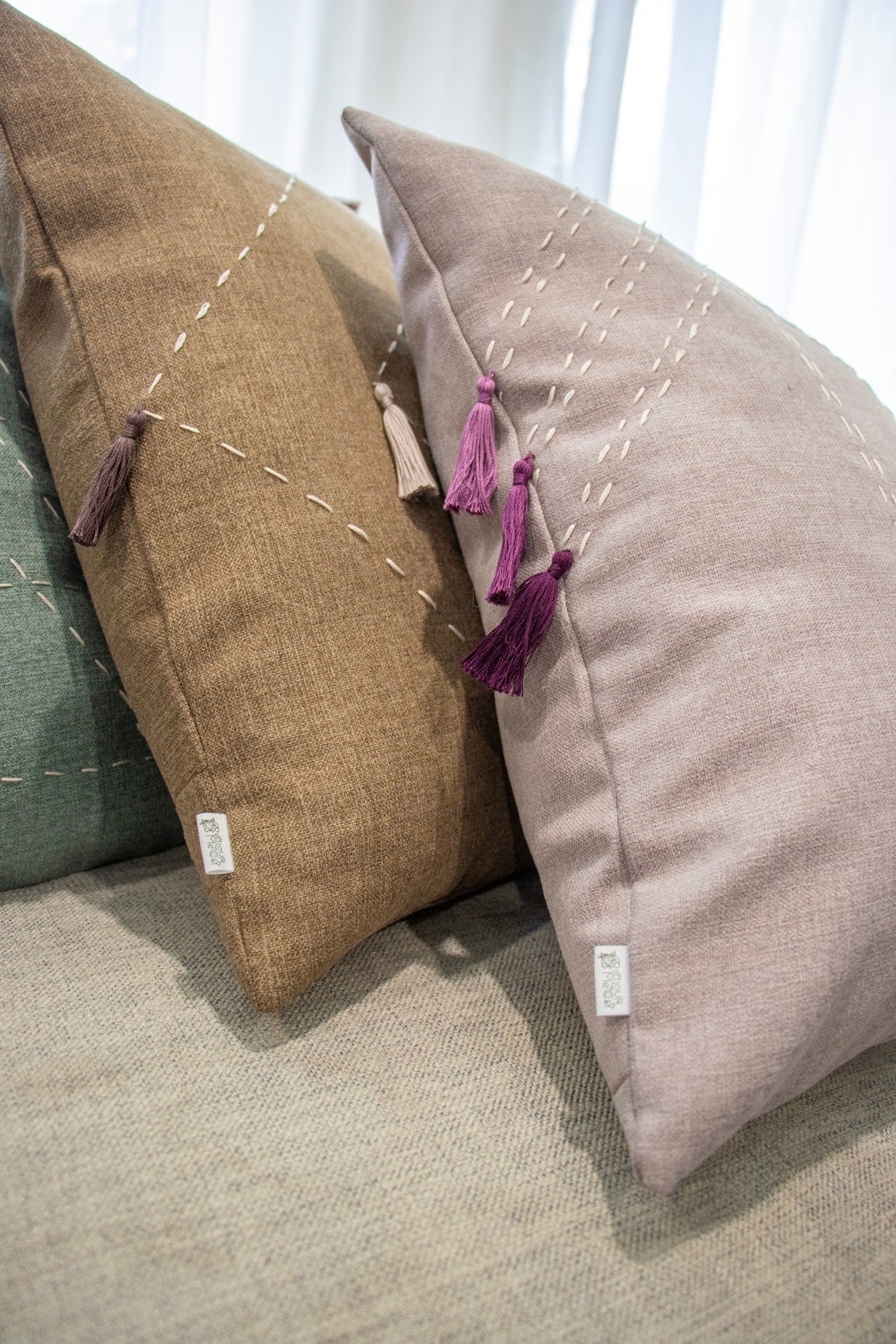 Close up of tassels on cushion cover with embroidery and tassels in loungeroom