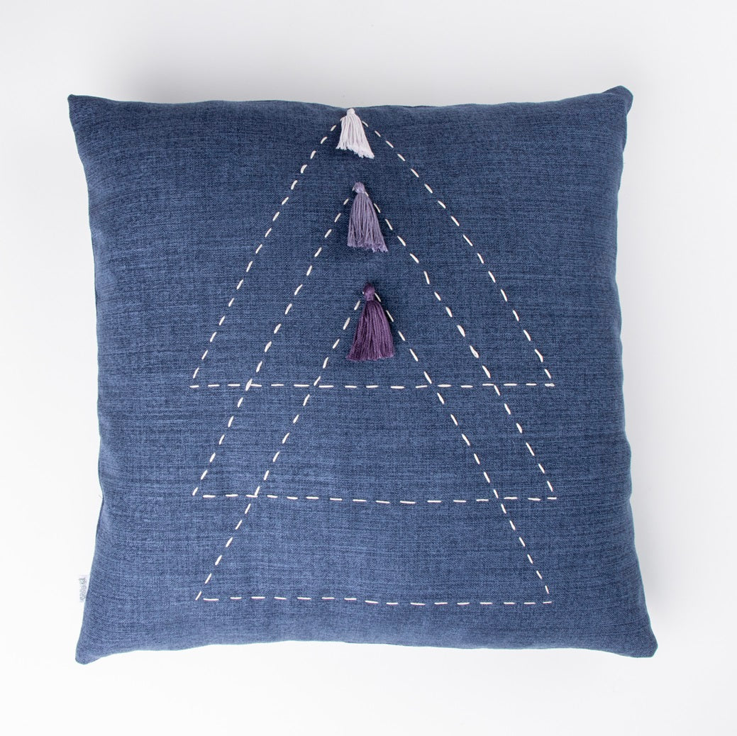 Front of blue triangle cushion cover with embroidery and tassels 