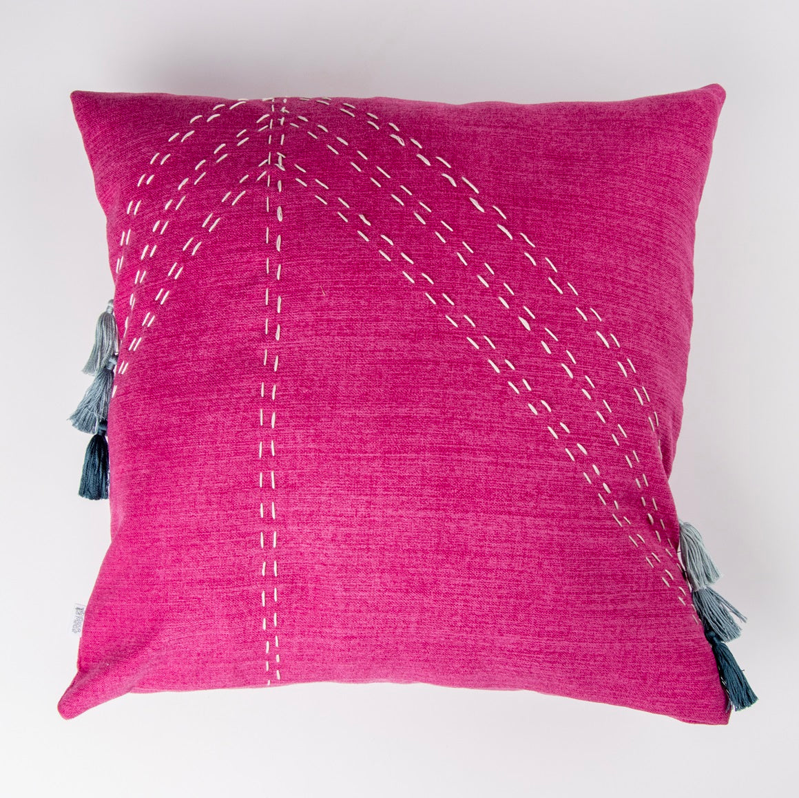 Front of Fushcia geometric cushion cover with embroidery and tassels