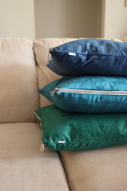 Stack of blue and green handmade textured velvet cushion cover with exposed zipper