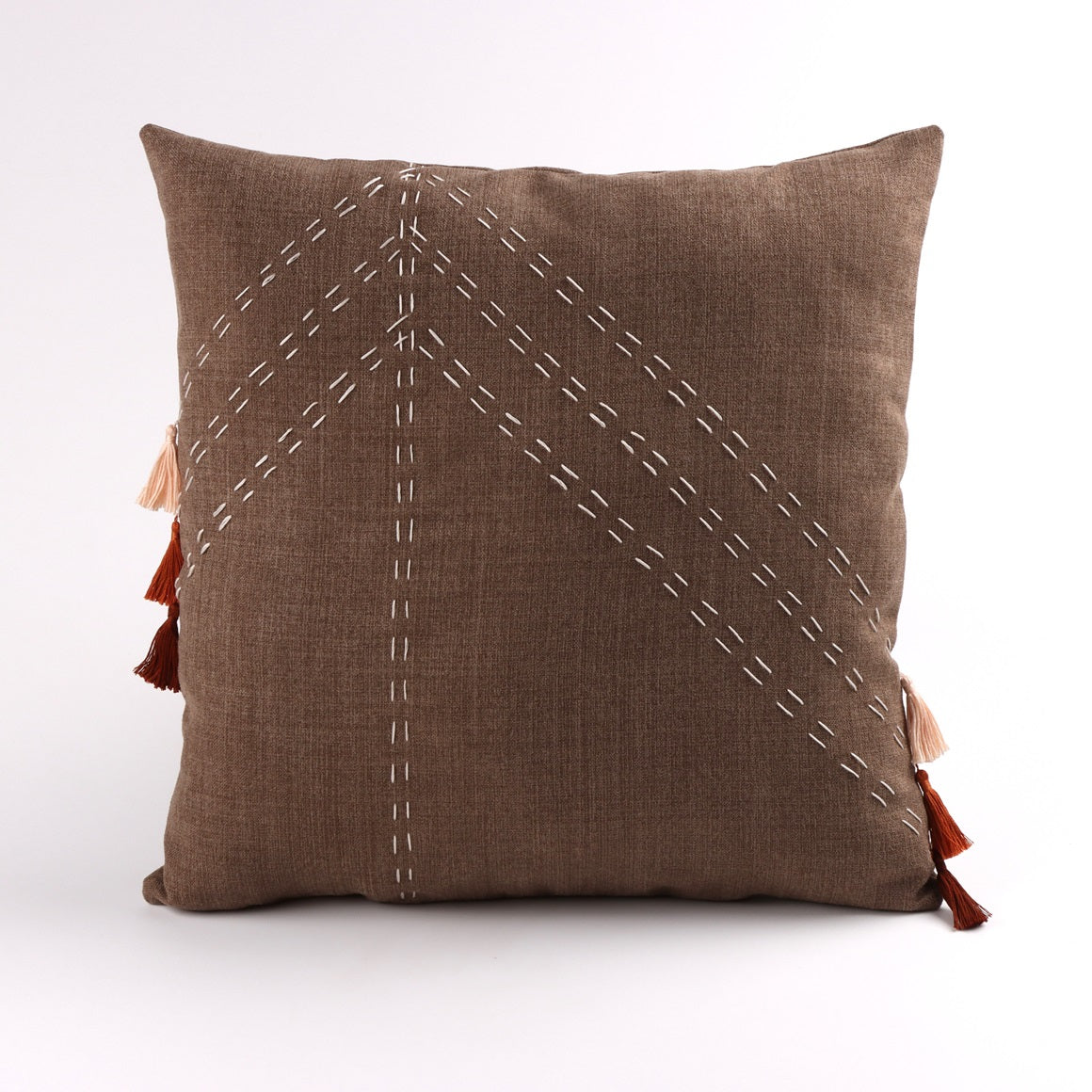 Front of brown geometric cushion cover with embroidery and tassels