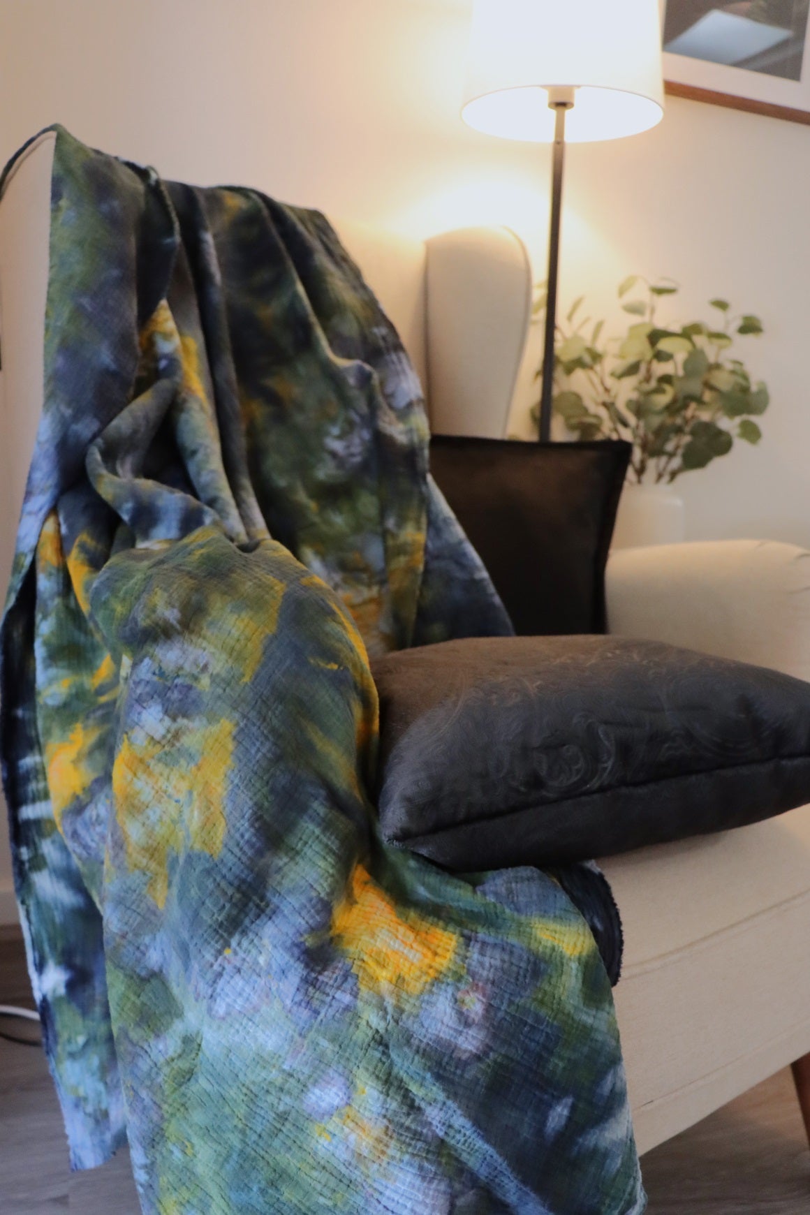 Lifestyle of yellow, green and black hand dyed ice-dyed cotton throw