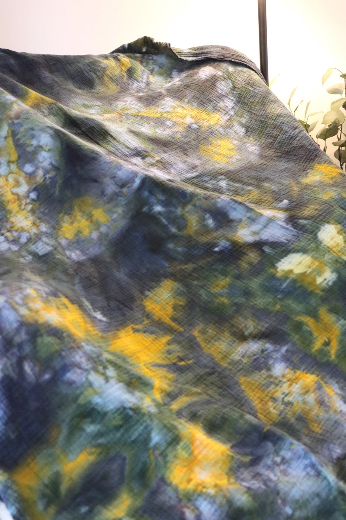 Close up of green, yellow and black ice-dyed cotton throw