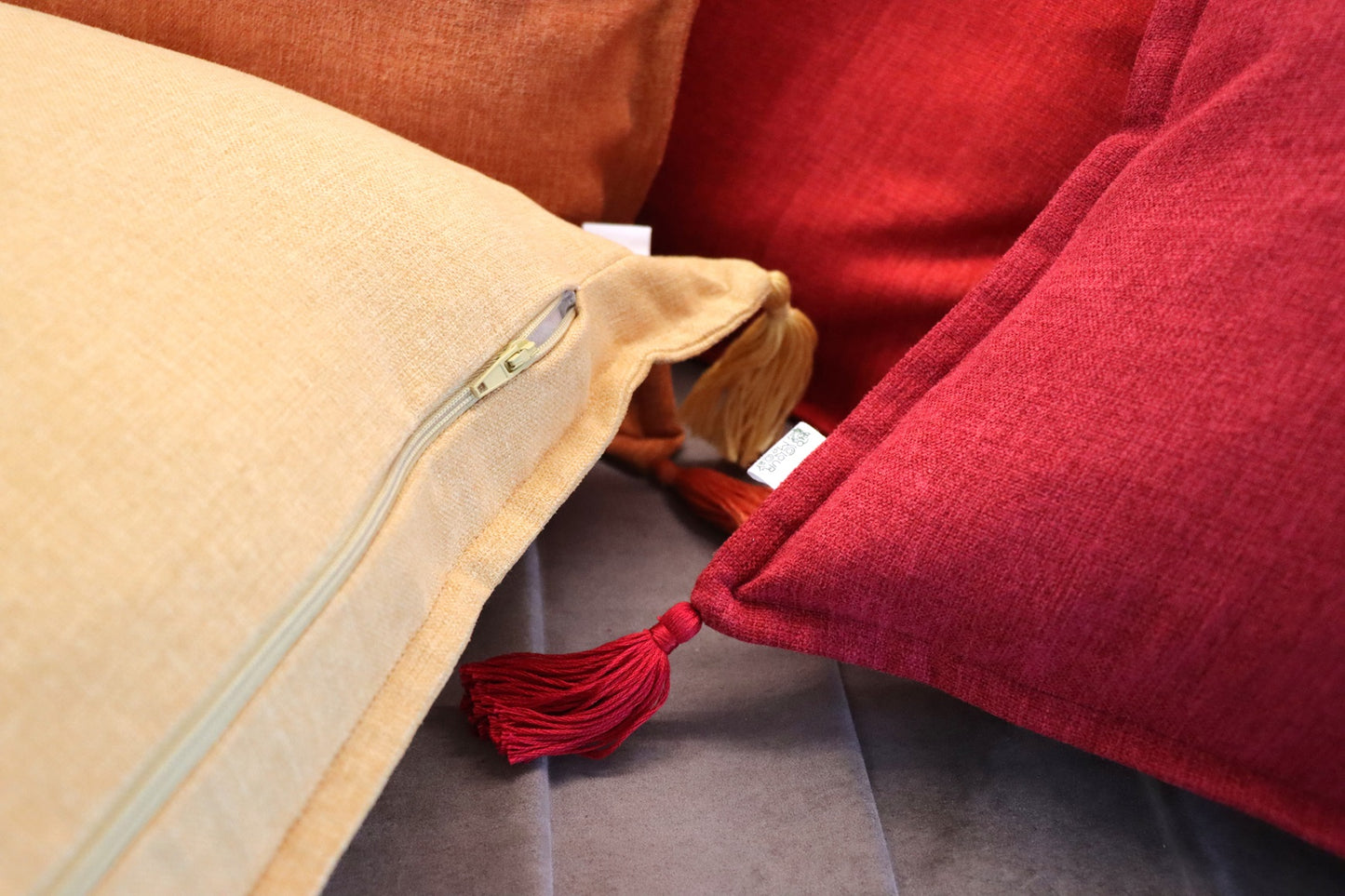 Close up of handmade cushion cover with tassels on couch