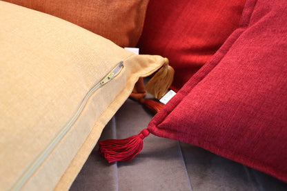 Close up of handmade cushion cover with tassels on sofa