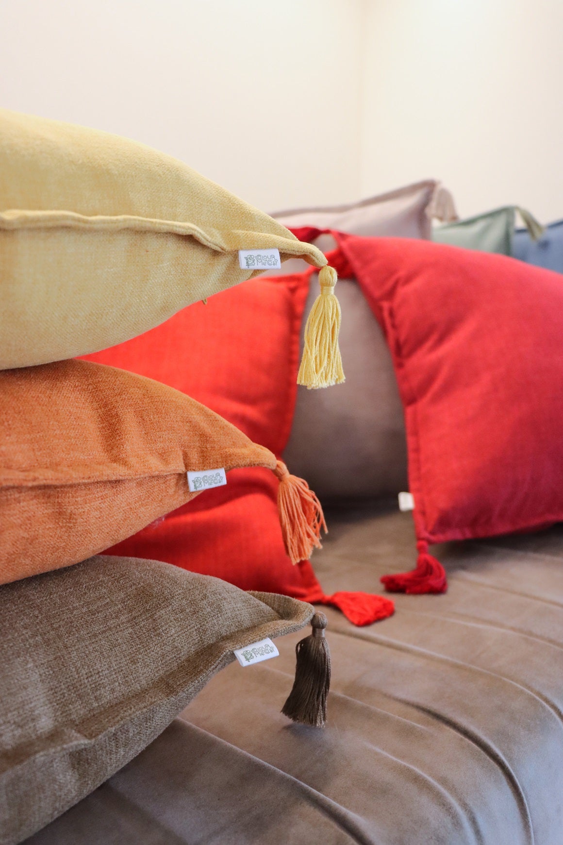 Stack of handmade cushion cover with tassels on sofa