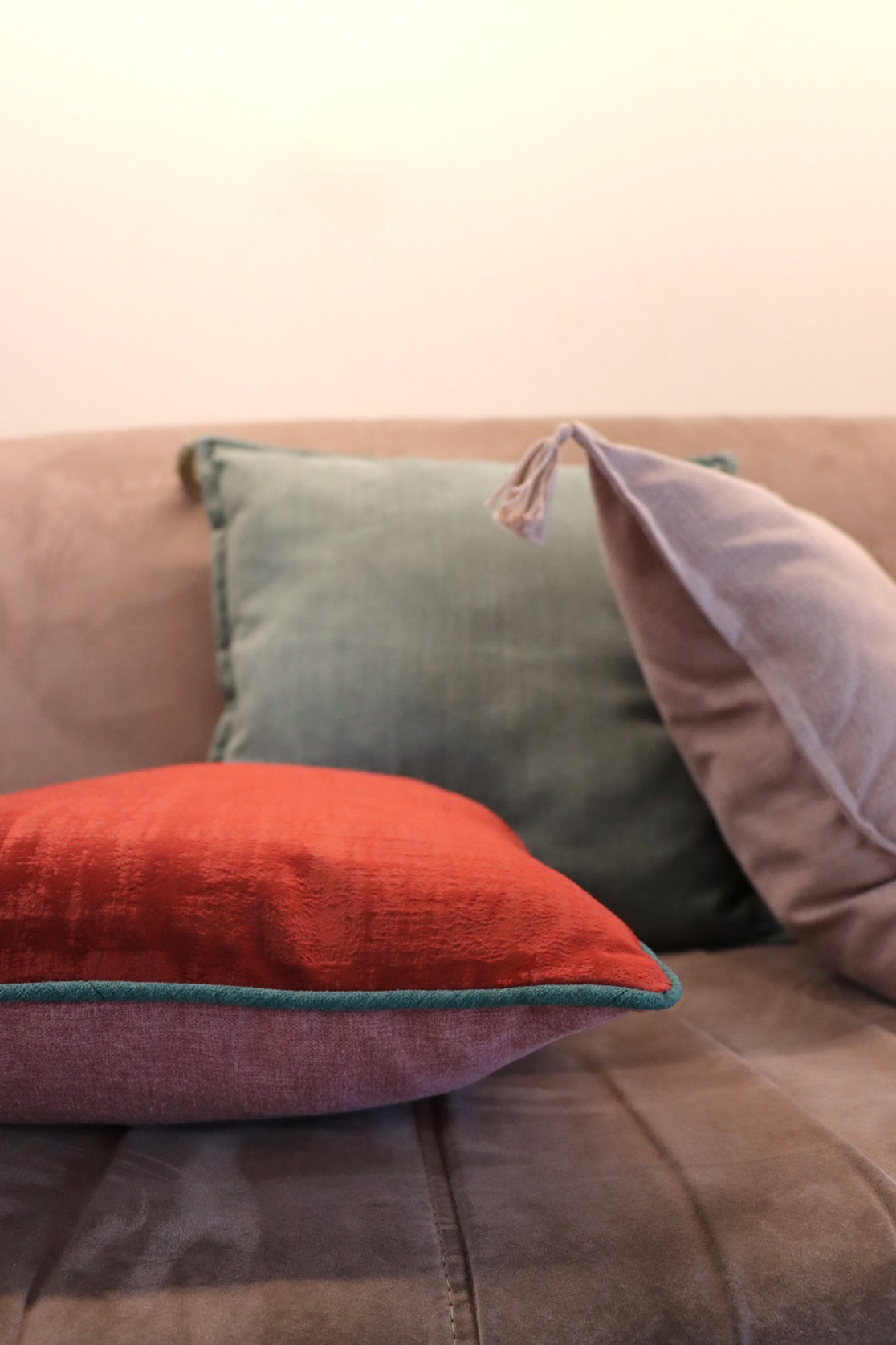 Lifestyle photo of velvet cushion cover with contrasting piping on sofa