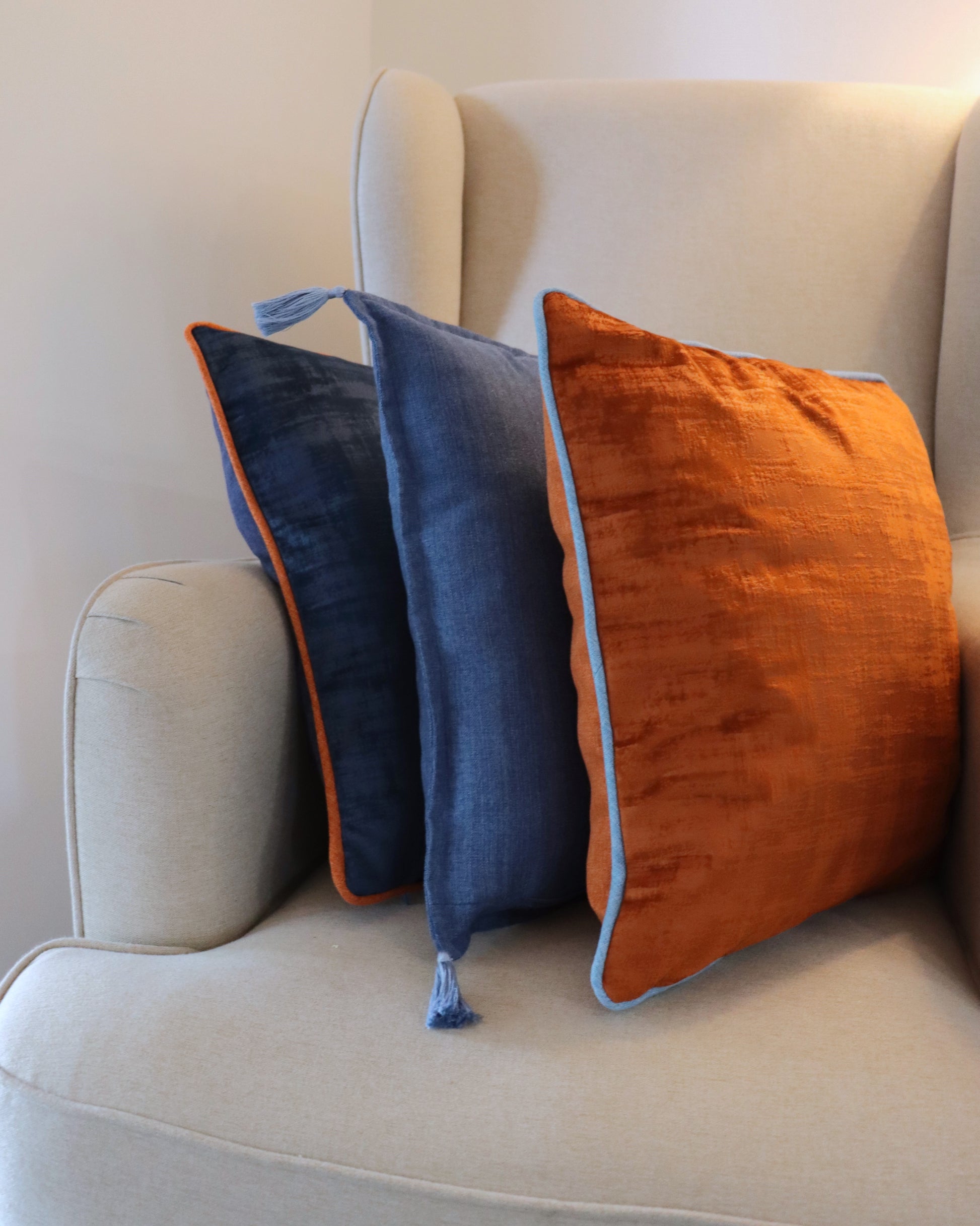 Lifestyle photo of handmade cushion cover with tassels on couch