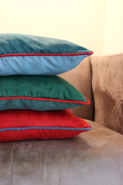 Stack of blue, red and green handmade Velvet Cushion Cover with Contrasting Piping