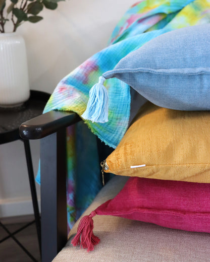 Stack of handmade cushion cover with tassels on chair