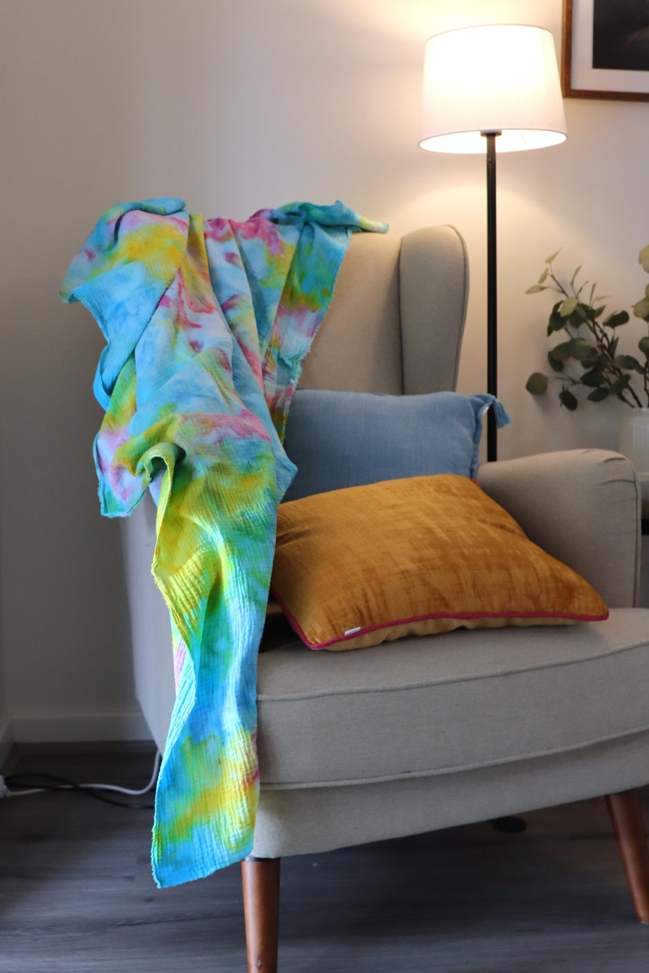 Lifestyle photo of yellow, pink and blue ice-dyed cotton throw on sofa