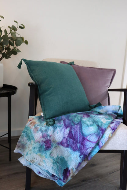 Folded purple and blue ice-dyed cotton throw on chair