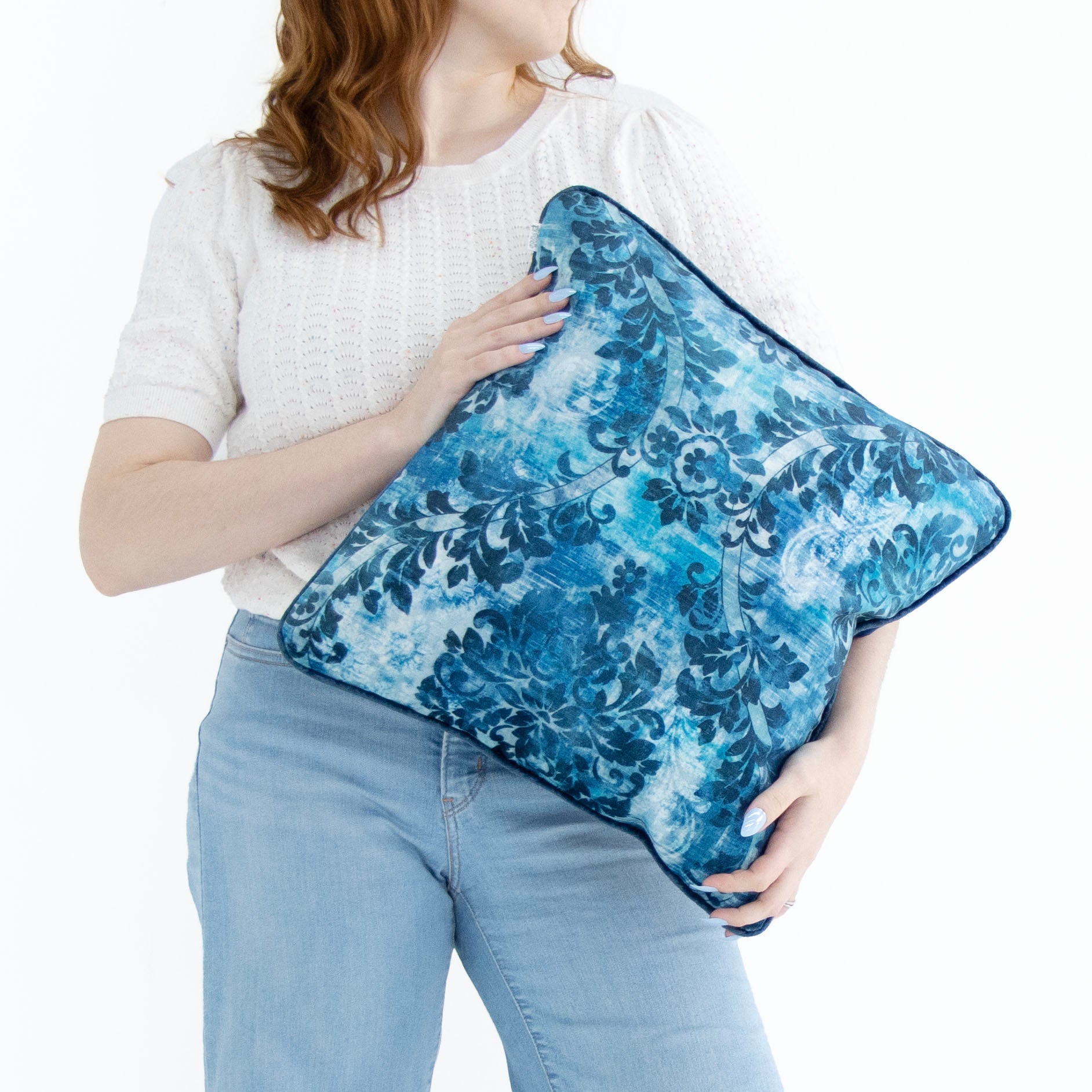 Lady holding cobalt blue floral cushion cover with piped edge