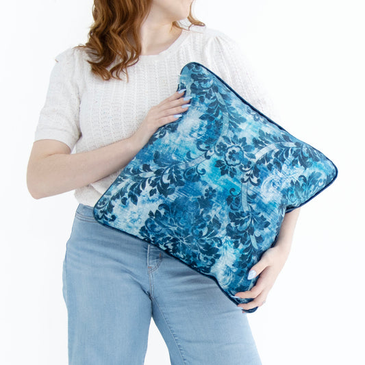 Lady holding cobalt blue floral cushion cover with piped edge