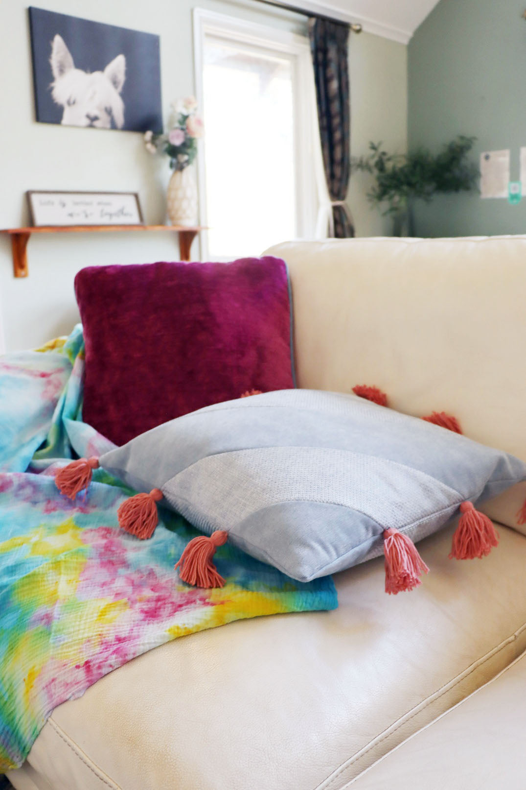 Colourful chenille cushion cover with contrasting piping on a couch in a living room setting.