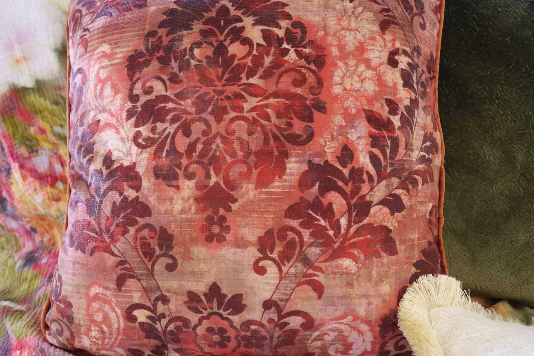 floral cushion cover with piped edge on a soft focus background