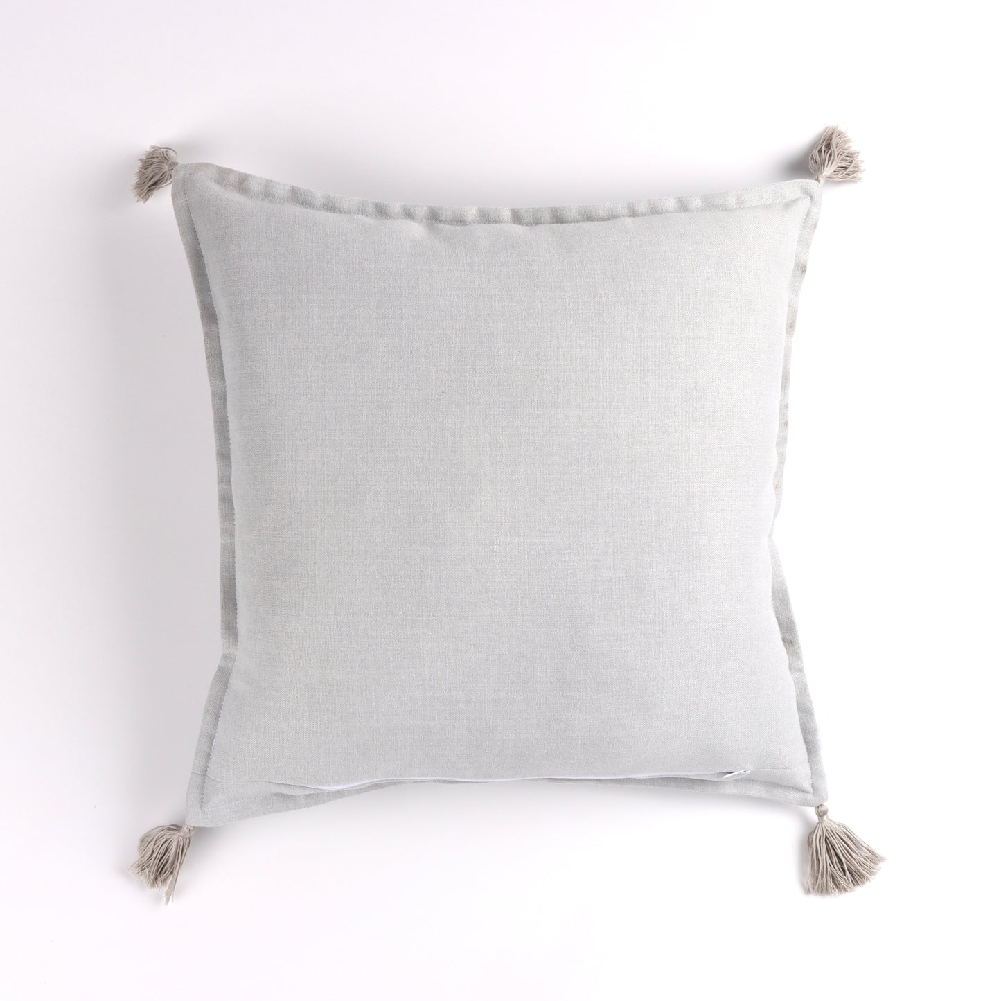 Back of white handmade cushion cover with tassels