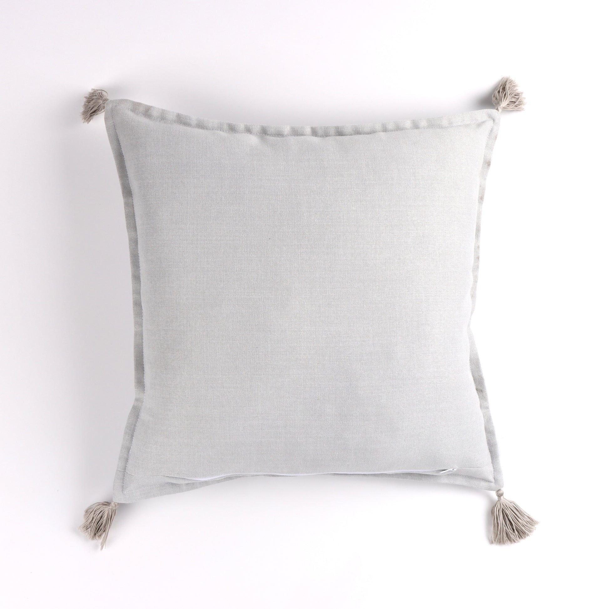 Back of white handmade cushion cover with tassels