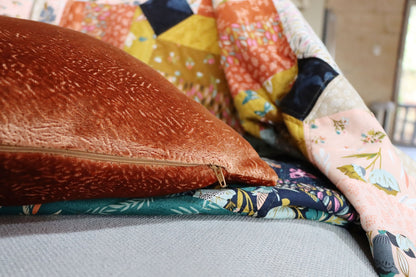 textured velvet cushion cover on a quilt