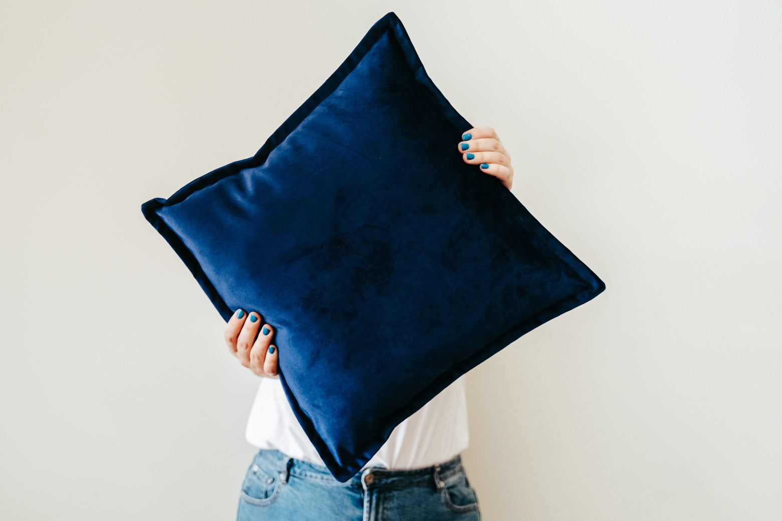 Person holding blue velvet cushion from quilt and cushion bundle