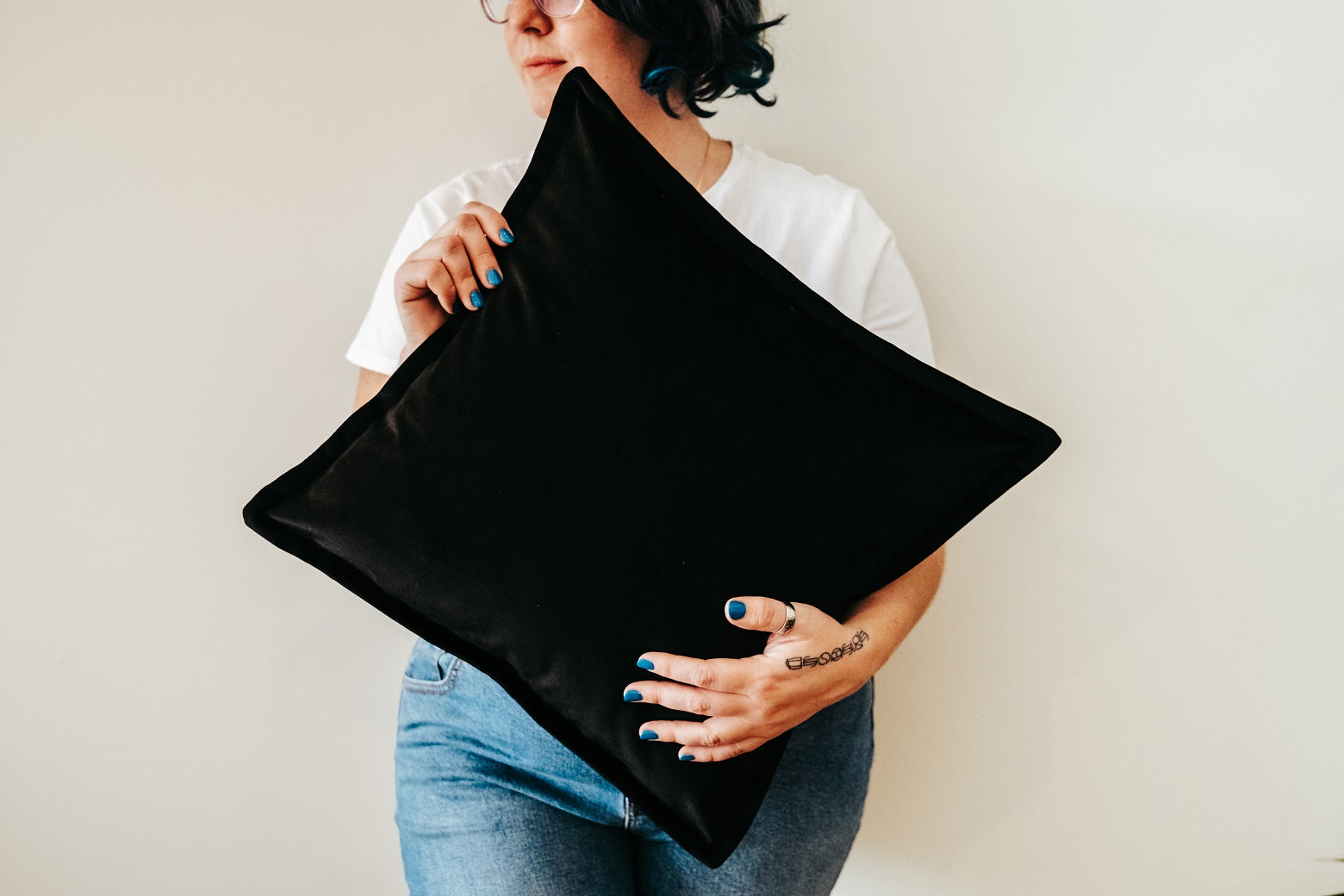 Person holding black velvet cushion from quilt and cushion bundle