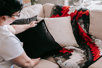 Lifestyle photo of red and black handmade quilt with mink backing handmade bargello quilt with mink backing on sofa