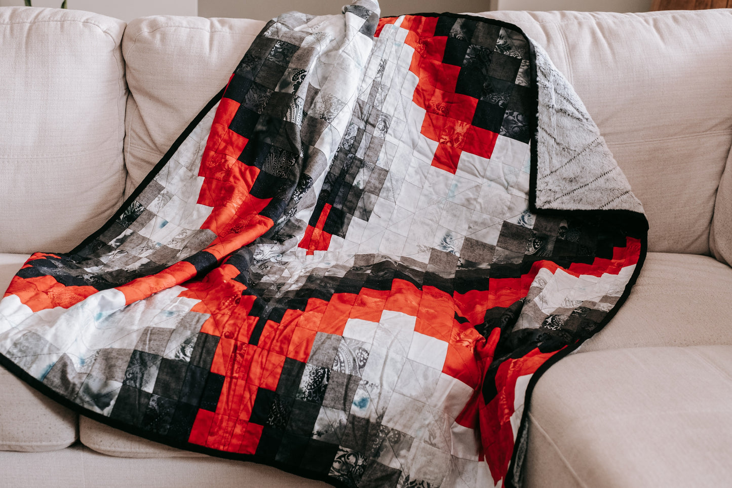 Lifestyle photo of handmade bargello quilt with mink backing