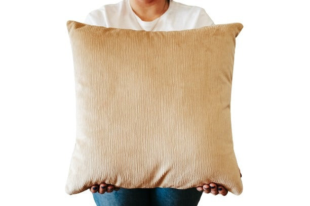 Person holding a light brown textured velvet cushion cover