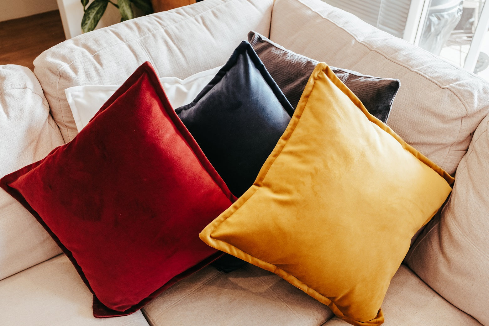 Lifestyle photo of velvet cushion cover with flange edging on couch
