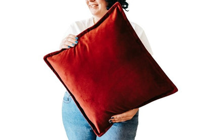 Person holding red velvet cushion cover with flange edging