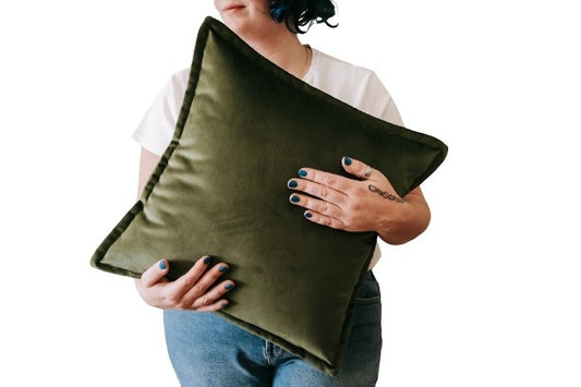 Person holding olive green velvet cushion cover with flange edging