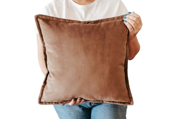 Person holding a brown velvet cushion cover with flange edging