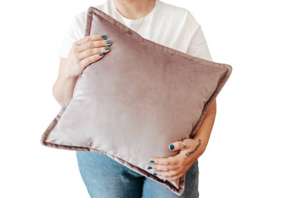 Person holding light purple velvet cushion cover with flange edging