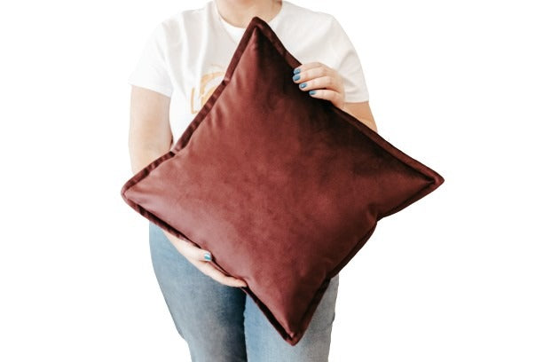 Person holding purple velvet cushion cover with flange edging