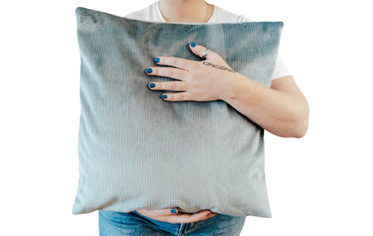 Person holding a green textured velvet cushion cover