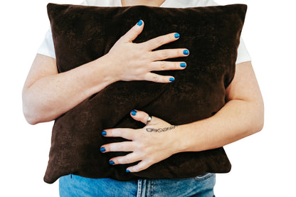 Person holding brown textured velvet cushion cover