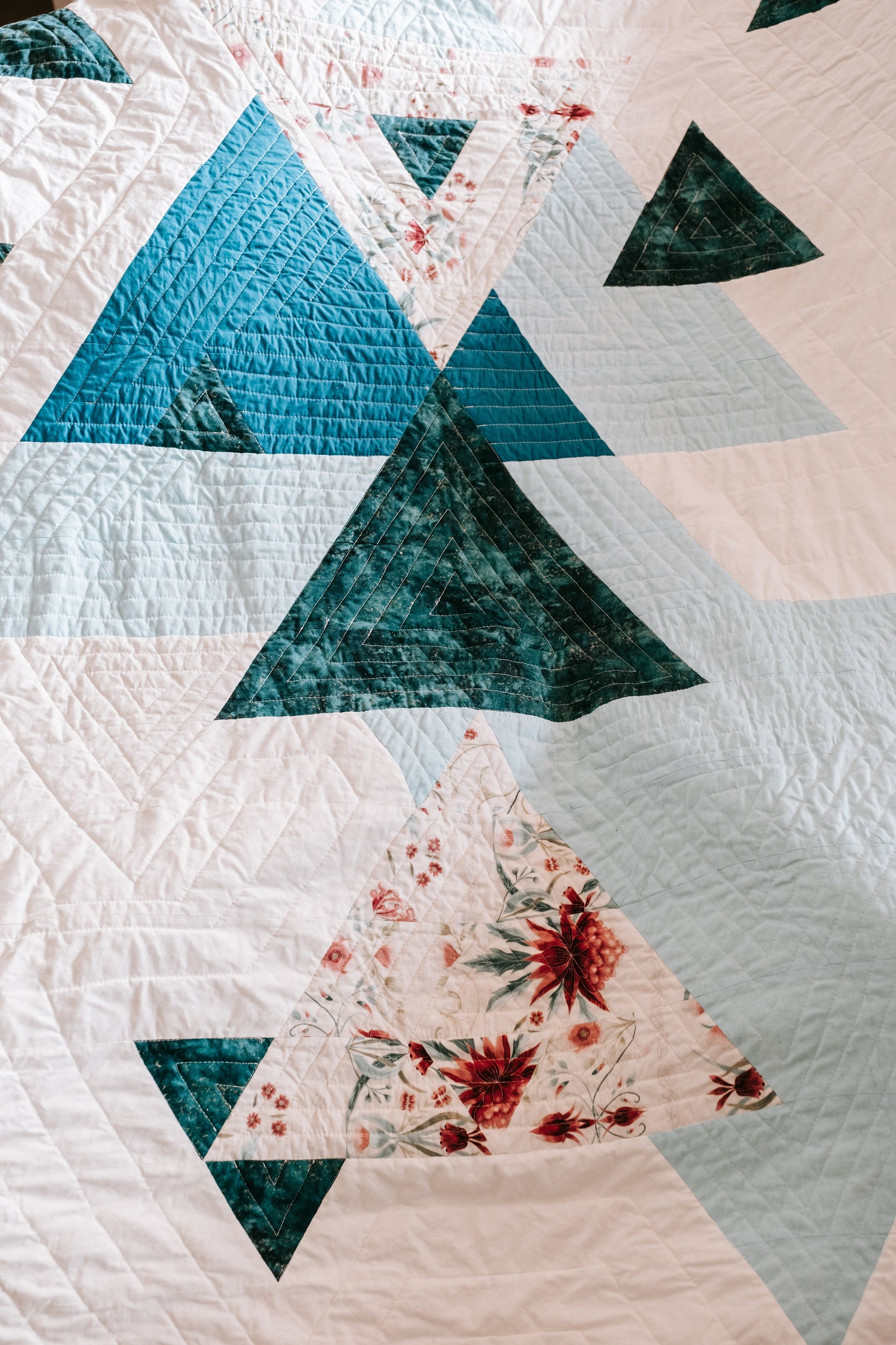 Close up of geometric handmade quilt with mink backing on sofa