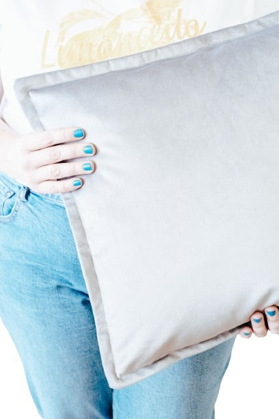 Person holding light grey velvet cushion cover with flange edging