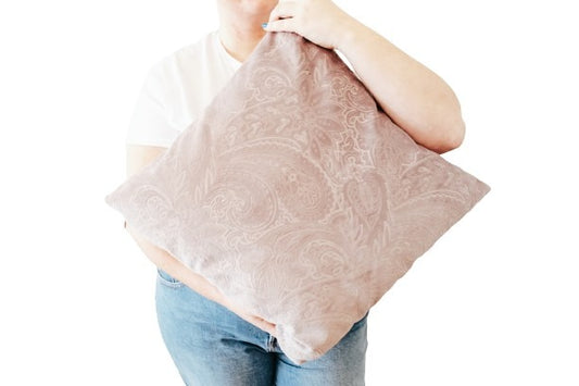 Person holding a textured velvet cushion cover