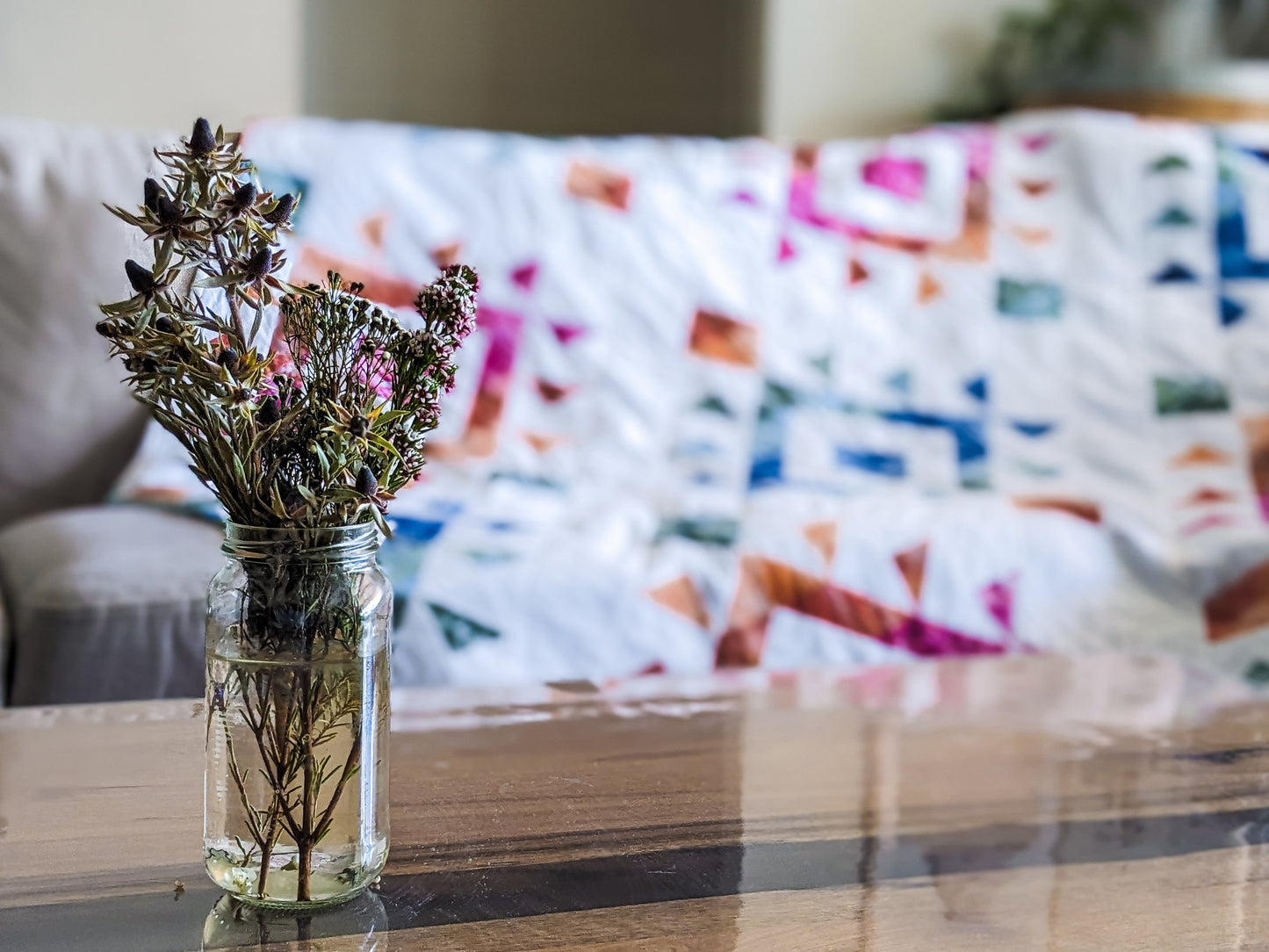 Lifestyle photo of handmade boho quilt with mink backing and flowers